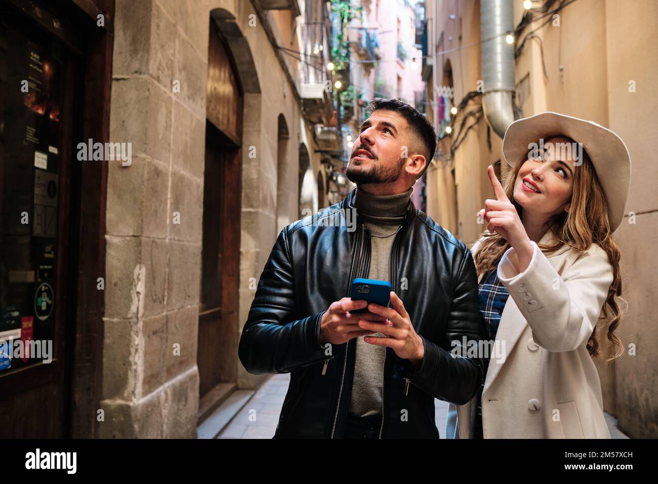 Ein Paar, das eine Stadt besucht und ein Handy benutzt Stockfoto