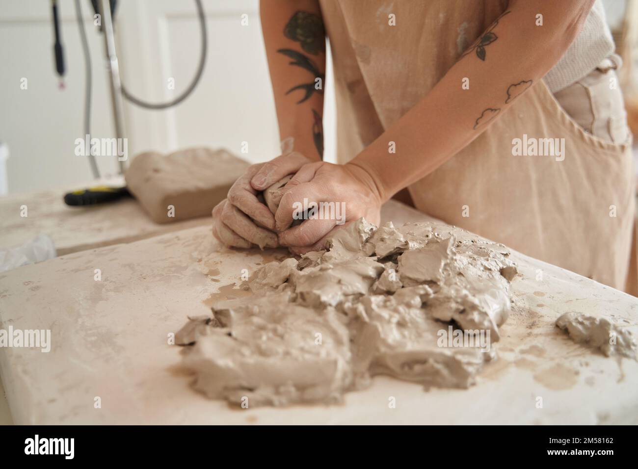 Nahaufnahme einer Frau, die mit Ton in einer Töpferwerkstatt arbeitet. Handwerk, Kunst und Hobbys. Stockfoto