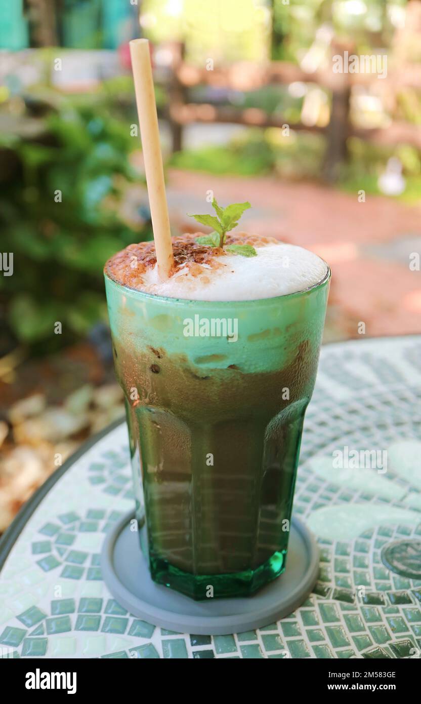 Iced Mint Cocoa Latte serviert auf dem Teetisch im Garten Stockfoto