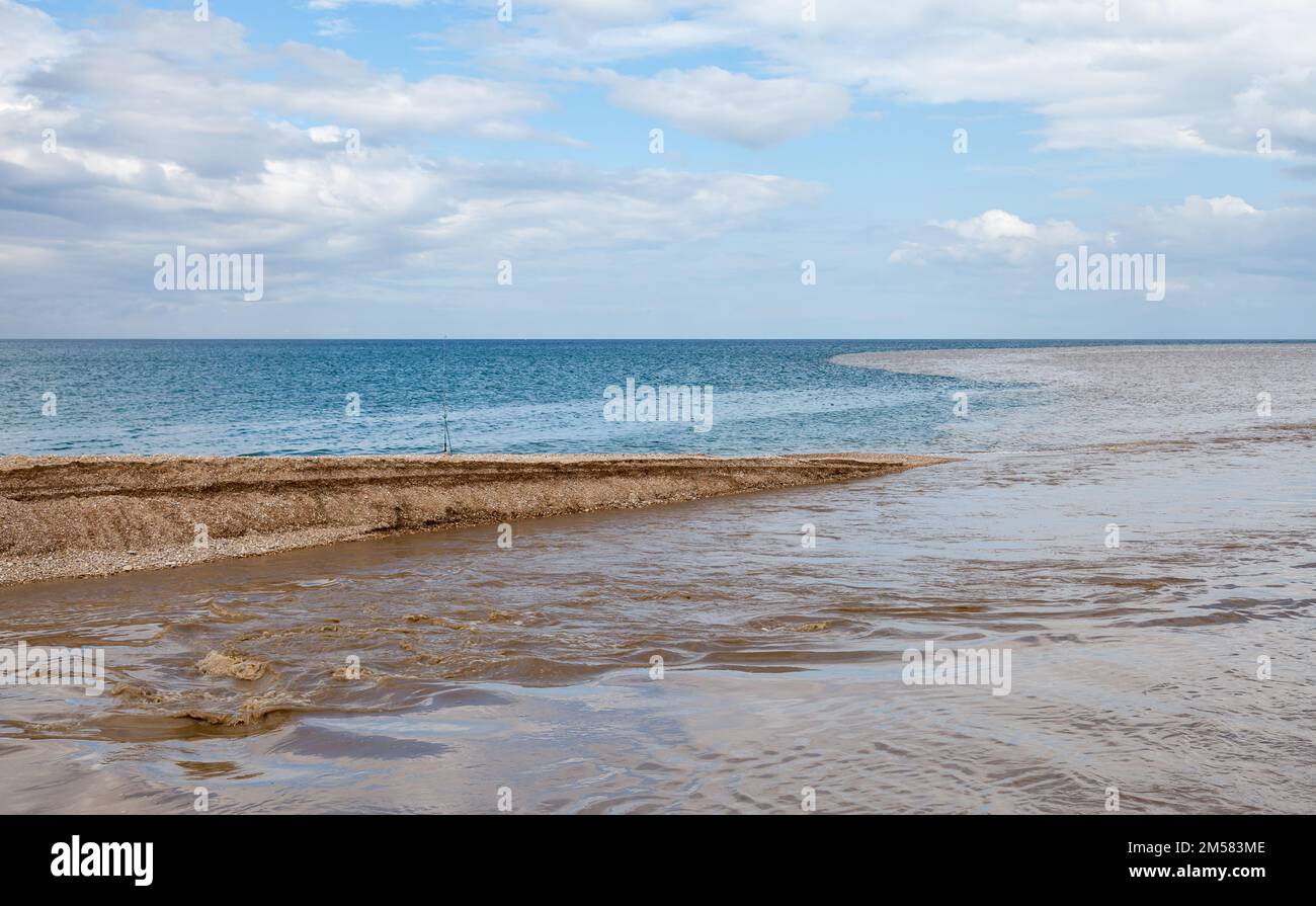 Sommerlandschaft mit schlammigen Gewässern des Belbek River, die sich an einem sonnigen Tag mit blauem Meerwasser vermischt. Krim Stockfoto