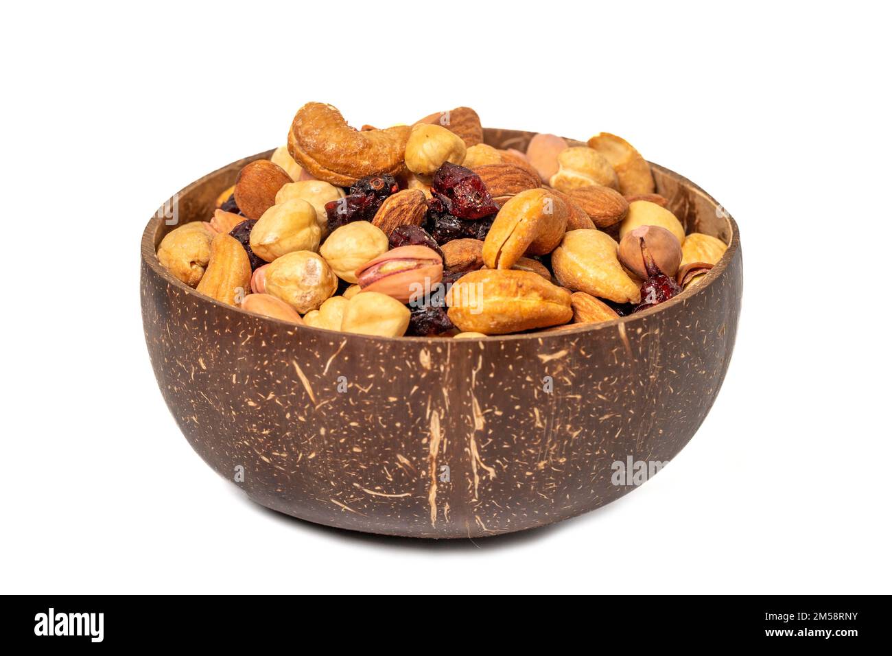 Gemischte Nüsse in Schüssel isoliert auf weißem Hintergrund. Nüsse, Cashews, Mandeln und Pistazien in einer Kokosnussschale. Schließen Stockfoto