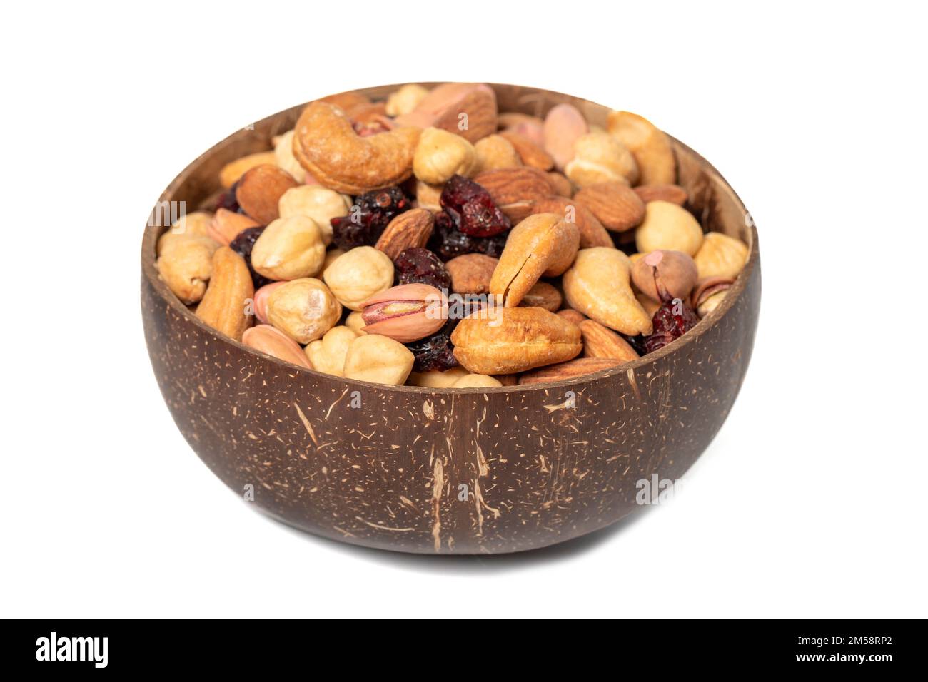 Gemischte Nüsse in Schüssel isoliert auf weißem Hintergrund. Nüsse, Cashews, Mandeln und Pistazien in einer Kokosnussschale. Schließen Stockfoto