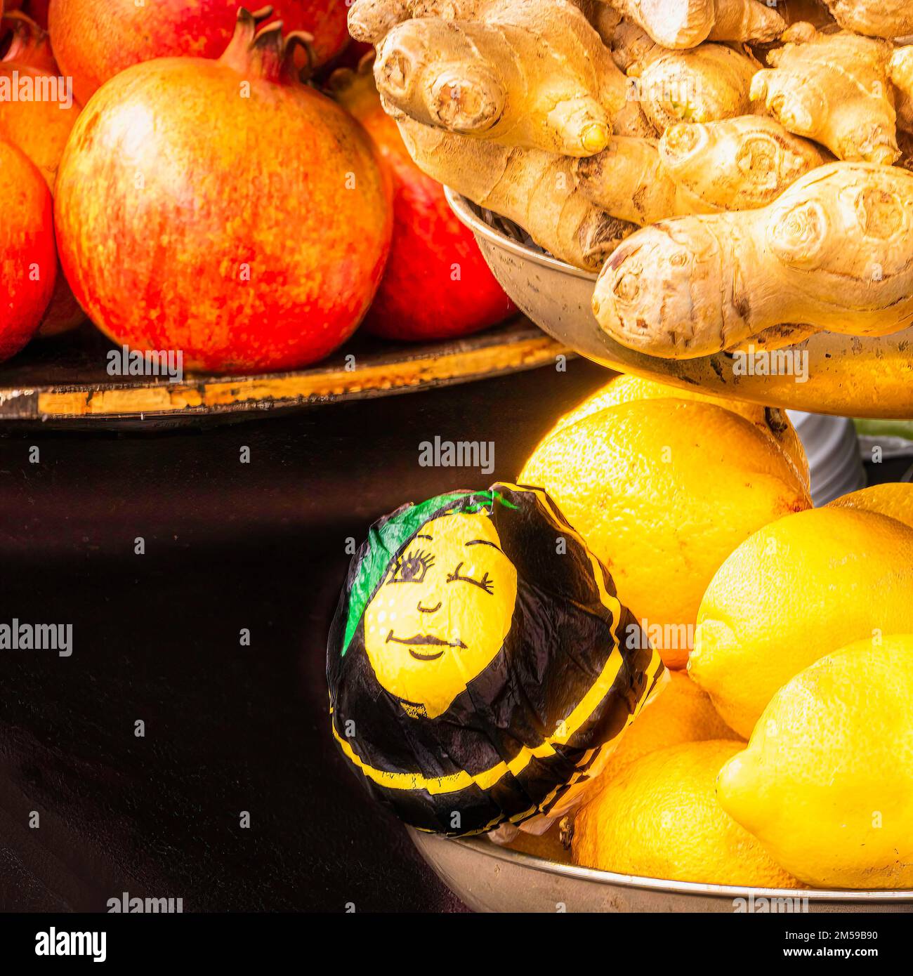 Stillleben mit Granatapfel, Zitrone und Ingwer auf Metallschalen Stockfoto