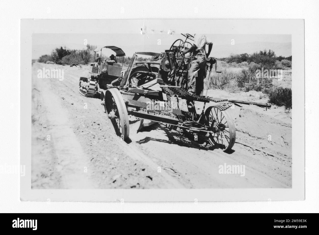 Originalüberschrift: "Beende die geölten Schultern der Straße. J. Aguilar, Traktorfahrer. H. King, Blademan, 1936. August." 1936 - 1942. Pazifikregion (Riverside, Kalifornien). Fotodruck. Innenministerium. Büro für Indianerangelegenheiten. Missionsbehörde. 11/15/1920-6/17/1946. Fotos Stockfoto