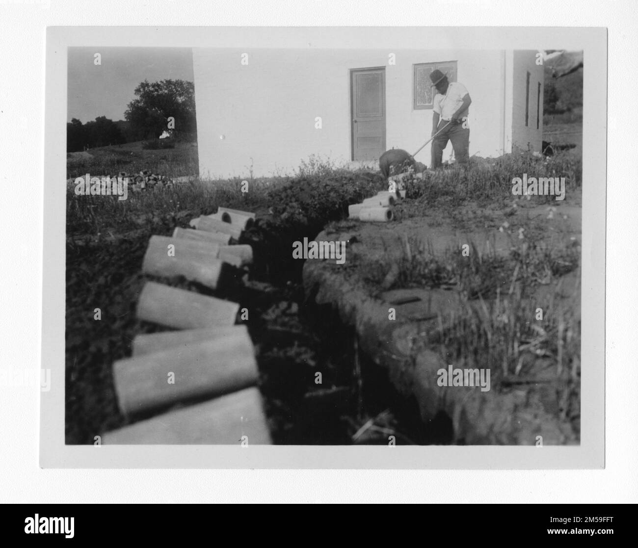 Originalunterschrift: "Indianer legen Abflussfliesen für Klärbecken im Barona-Heim." 1936 - 1942. Pazifikregion (Riverside, Kalifornien). Fotodruck. Innenministerium. Büro für Indianerangelegenheiten. Missionsbehörde. 11/15/1920-6/17/1946. Fotos Stockfoto