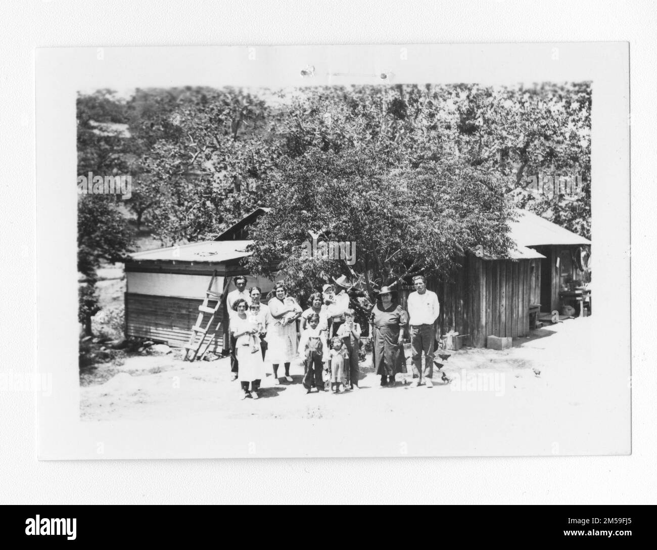 Originalunterschrift: 'Foto Nr. 1 Ed Guachene Familie und zwei andere Familien, insgesamt 14 in diesem Haus. Aufgenommen bei Beginn des Baus eines neuen Hauses unter IR&R für Ed Guachene, um Überbelegung zu vermeiden. Vier in der Familie Guachene. 1. Juni 1936. 1936 - 1942. Pazifikregion (Riverside, Kalifornien). Fotodruck. Innenministerium. Büro für Indianerangelegenheiten. Missionsbehörde. 11/15/1920-6/17/1946. Fotos Stockfoto