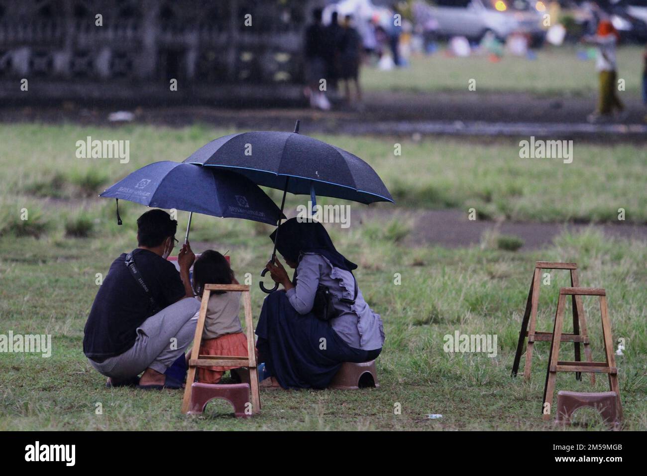 27. Dezember 2022, Yogyakarta, Sonderregion von Yogyakarta, Indonesien: Eltern schwingen ihre Kinder, die in Yogyakarta malen. Die National Disaster Management Agency (BNPB) erinnert die Menschen daran, bei extremen Wetterbedingungen, wie starkem Regen, Überschwemmungen und Stürmen, nicht auf Reisen oder Jahresferien zu bestehen. BNPB prognostiziert extreme Wetterbedingungen in Form von starkem Regen und Stürmen am Mittwoch (28. Oktober 12) morgen. BNPB wird außerdem Wettermodifizierungstechnologien einsetzen, um extremen Wetterbedingungen vorzubeugen. Auch die Agentur für Meteorologie, Klimatologie und Geophysik (BMKG) fragte das Publi Stockfoto