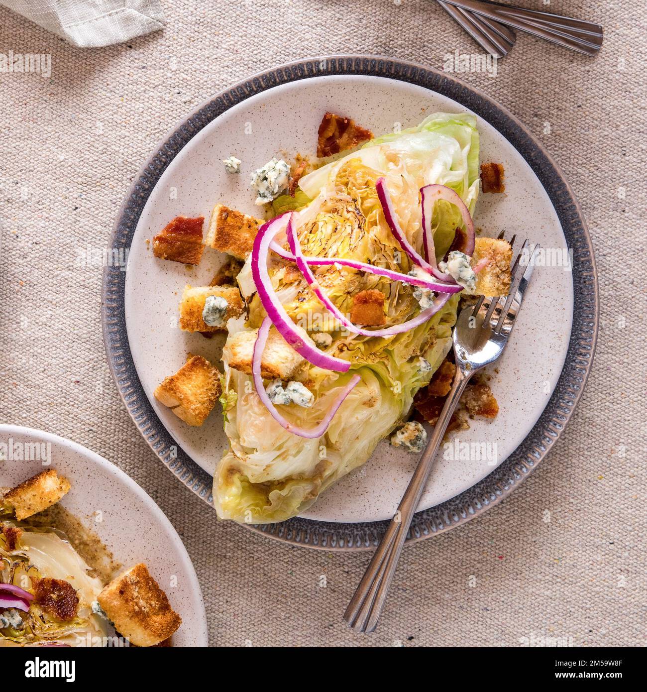 Eine Servierung von warmem Keilsalat garniert mit Croutons, roten Zwiebeln und Speck. Stockfoto