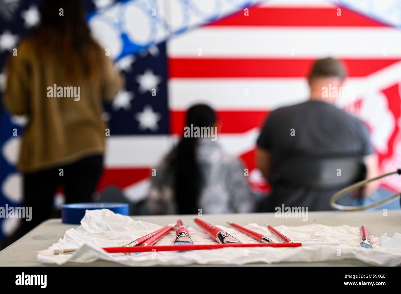 Mitglieder der Task Force Liberty arbeiten mit Gästen zusammen, um ein Wandgemälde zu malen, das die Reise der afghanischen Umsiedlung von Afghanistan in die Vereinigten Staaten darstellt, während sie am 14. Februar 2022 auf der Joint Base McGuire-Dix-Lakehurst, New Jersey, waren. Das Verteidigungsministerium, durch die USA Das Northern Command und zur Unterstützung des Department of Homeland Security bietet so schnell wie möglich Transport, temporäre Unterbringung, medizinische Untersuchungen und allgemeine Unterstützung für mindestens 11.000 afghanische Evakuierte in Liberty Village in permanenten oder temporären Strukturen. Diese Initiative bietet afghanischem Personal wesentliche Unterstützung Stockfoto