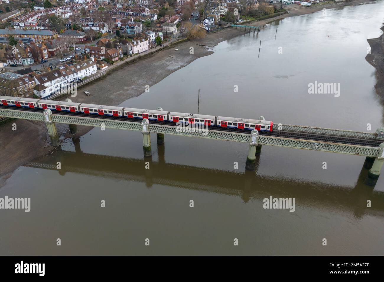 Luftaufnahme der Kew Railway Bridge über die Themse, mit einem Zug der Londoner U-Bahn-Linie, der an Kew, London, Großbritannien vorbeifährt. Stockfoto