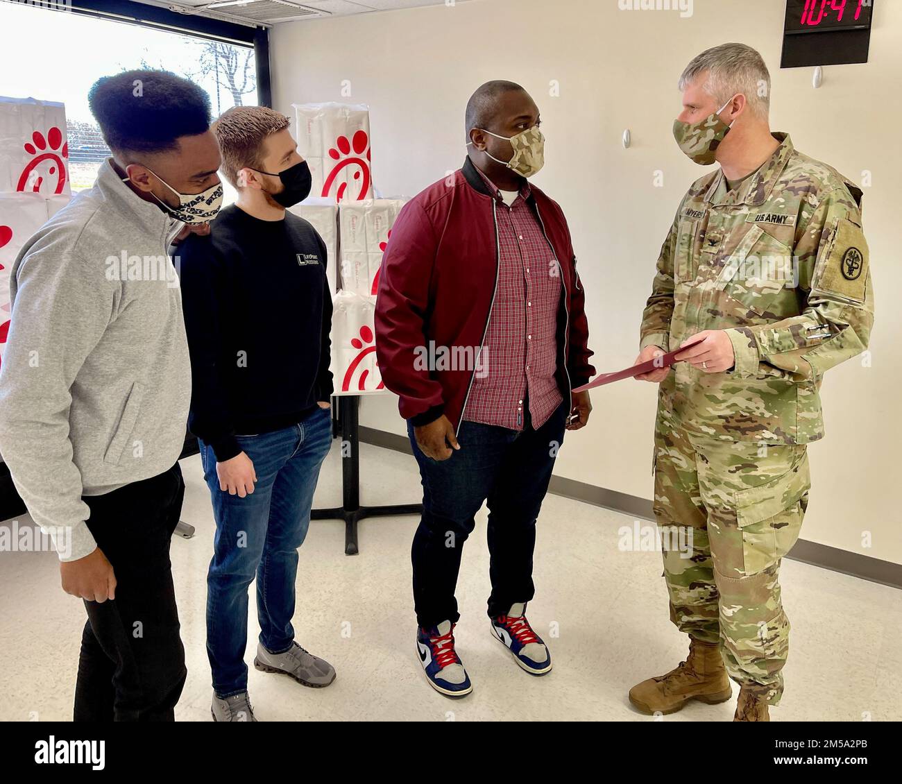 Blanchfield Army Community Hospital Commander, Oberst Vincent B. Myers spricht mit den Pastoren der LifePoint Church (von links) Mark Benton, II., Christian Christenson und Willie Simpson, bevor sie ihnen im Oberfeldwebel Major Classroom des Krankenhauses am 14. Februar einen Dankesschein vorlegen. Die Pastoren besuchten das Krankenhaus, um dem Personal ein Mittagessen zu geben. Kirchenvertreter erklärten, dass ihre Gemeinde in Clarksville, Tennessee, den Angehörigen der Gesundheitsberufe, die die COVID-19-Reaktion in der Gemeinde unterstützen, ihre Wertschätzung zeigen wollte. Stockfoto