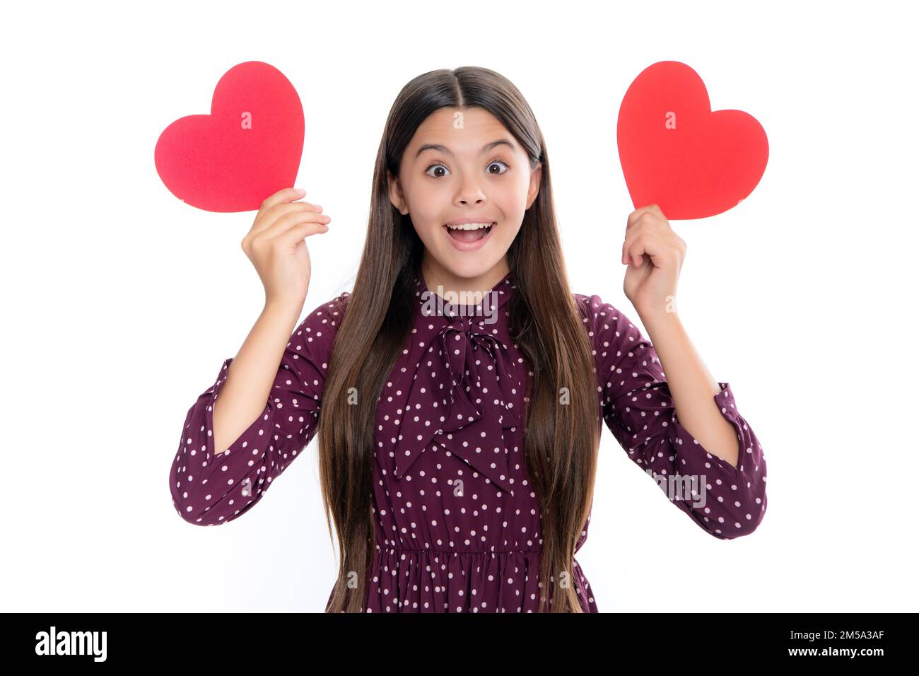 Fröhliches, liebenswertes, romantisches Teenager-Mädchen mit rotem Herz Symbol der Liebe für den Valentinstag isoliert auf weißem Hintergrund. Porträt von emotionaler Erstaunen erregt Stockfoto