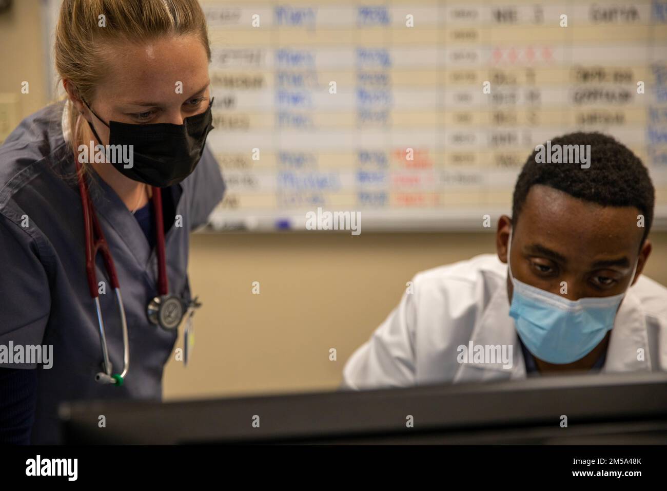 WEST COVINA, KALIFORNIEN, USA Air Force 1. LT. Katelyn Warren, Ärztin und US Air Force Capt. Ramsey Gardner, eine Ärztin für Innere Medizin, die beide der Luftwaffenbasis Travis, Kalifornien, zugeteilt sind, diskutieren die Patientenversorgung im Emanate Health Queen of the Valley Hospital in West Covina, Kalifornien, 14. Februar 2022. Die Airmen werden aus Kalifornien entsandt, um die fortgesetzten Maßnahmen zur Bekämpfung von COVID-Infektionen des Verteidigungsministeriums zu unterstützen, um notleidenden Gemeinschaften zu helfen. USA Nördliches Kommando, durch die USA Army North, bleibt entschlossen, dem gesamten Volk flexible Unterstützung des Verteidigungsministeriums zu gewähren Stockfoto