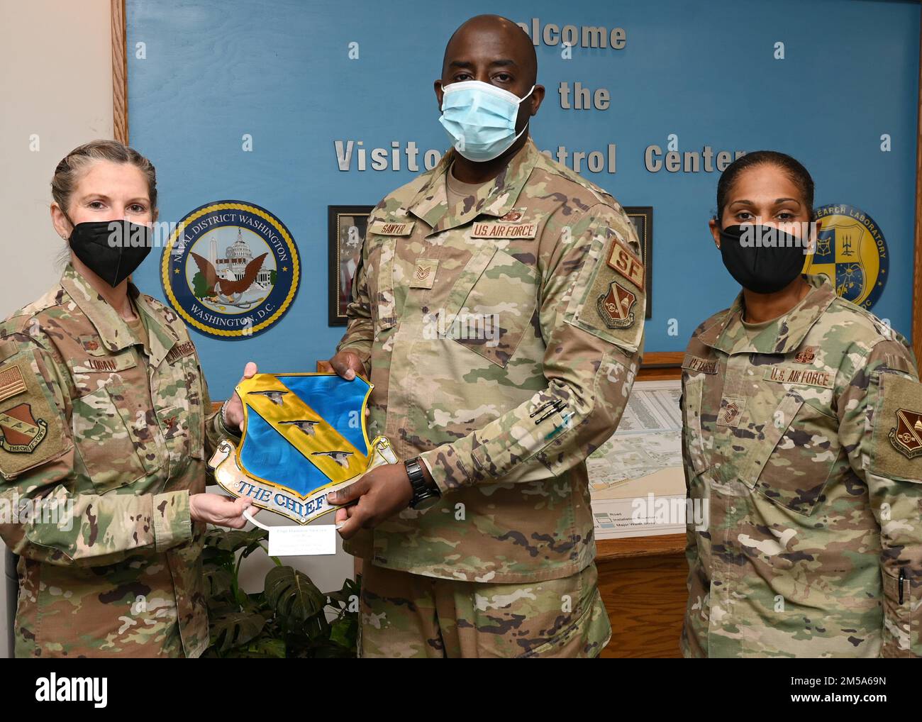 Joint Base Anacostia-Bolling Commander, USA Oberst Cat Logan der Luftwaffe und Oberbefehlshaber Christy Peterson, hier Tech. Sgt. Damien Sawyer, Joint Visitor Center NCO in der Leitung, mit seinem Volunteer of the Year Award am 14. Februar 2022, bei JBAB, Washington, D.C. Sawyer wurde für seine Dienste außerhalb der Zaunlinie und im ganzen Land anerkannt. Stockfoto