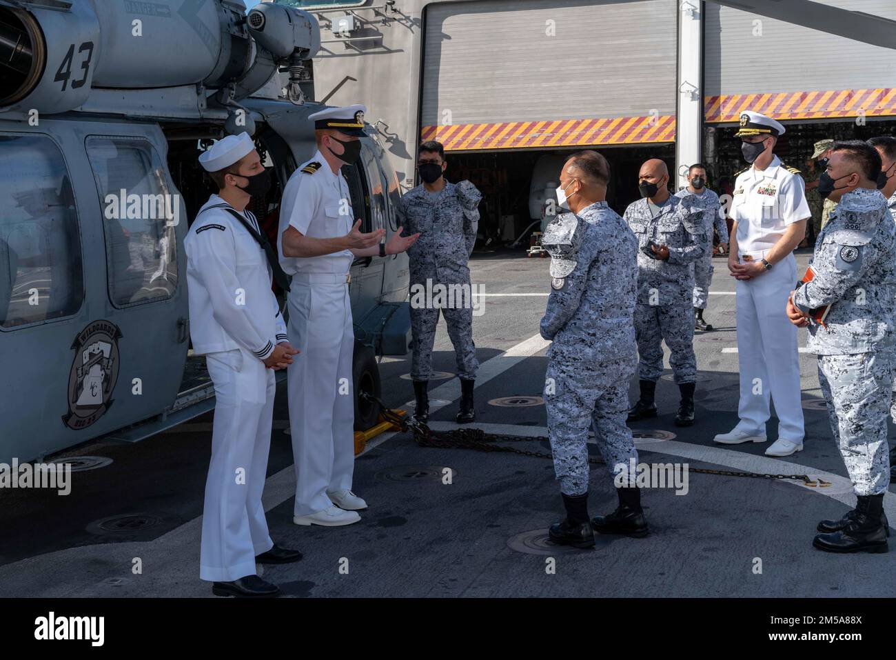 220215-N-FA490-1109 MANILA, Philippinen (15. Februar 2022) – LT. Cmdr. Mike Feay, Zweiter von links, aus Papillion, Nebraska, angeschlossen an Helicopter Sea Combat Squadron (HSC) 23, dem Independence-Variant littoral Combat Schiff USS Jackson (LCS 6) zugeteilt, beantwortet Fragen zu einem MH-60s Hubschrauber vom Flaggenbeamten, Philippine Navy, Vice ADM. Adeluis Bordado, Mitte rechts, Auf dem Flugdeck von Jackson. Am Destroyer-Geschwader (DESRON) 7 sind Jackson und HSC-23 im Rotationseinsatz im US-7.-Flottengebiet, um die Sicherheit und Stabilität im zu unterstützen Stockfoto