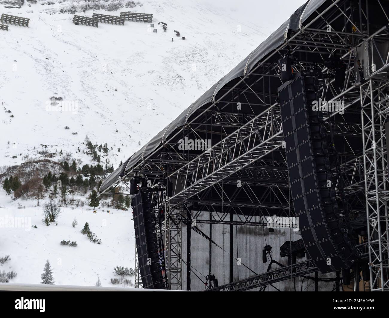 Bühnenausrüstung für ein Freiluftkonzert im Skigebiet in der Wintersaison. Truss-Rahmenkonstruktion mit lauten Lautsprechern und Beleuchtungseinrichtungen. Stockfoto