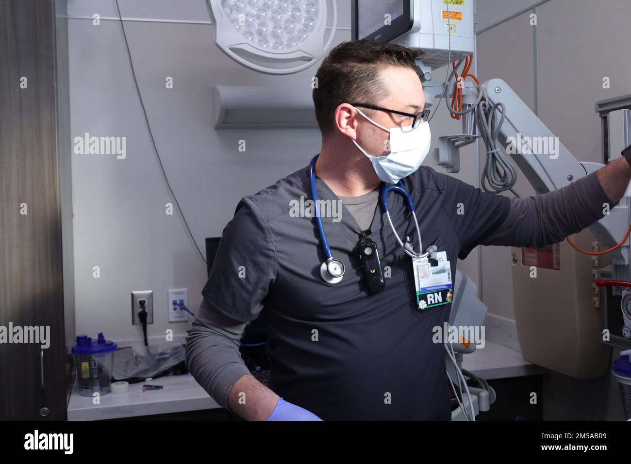 BUFFALO, NEW YORK. - AUS DEN USA Leutnant Commander Der Marine. David Johnson, eine Krankenschwester in der Notaufnahme, die einem militärisch-medizinischen Team zugewiesen ist, testet die Temperatur eines Patienten und unterstützt gleichzeitig die COVID-Response-Operationen am Erie County Medical Center, Buffalo, New York, 15. Februar 2022. USA Nördliches Kommando, durch die USA Army North ist nach wie vor entschlossen, das Verteidigungsministerium flexibel bei der COVID-Reaktion der gesamten Regierung zu unterstützen. Stockfoto