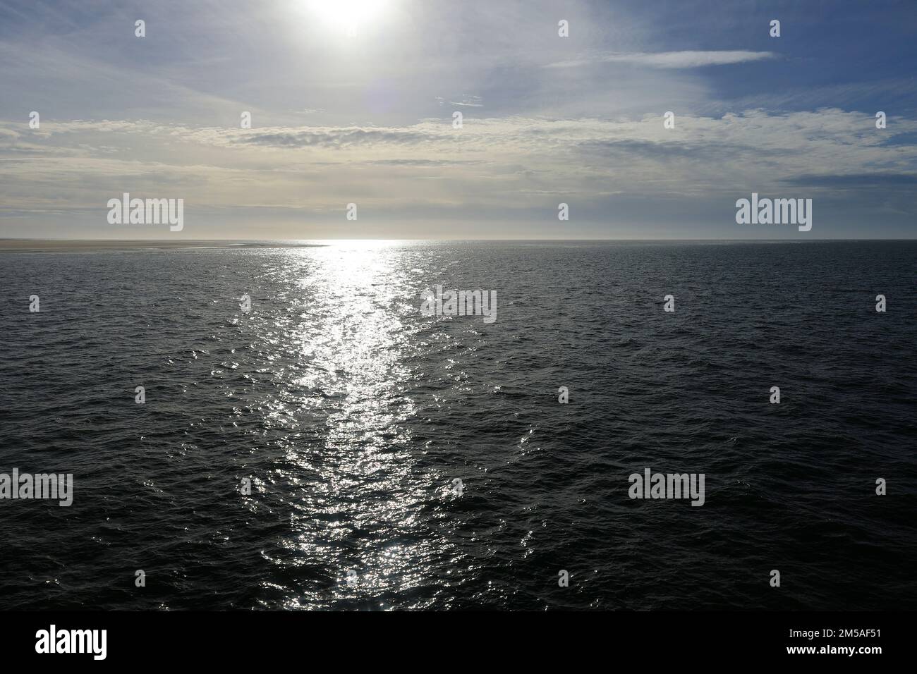 Die Sonne scheint auf die Nordsee und die Strahlen brechen auf den Wellen Stockfoto