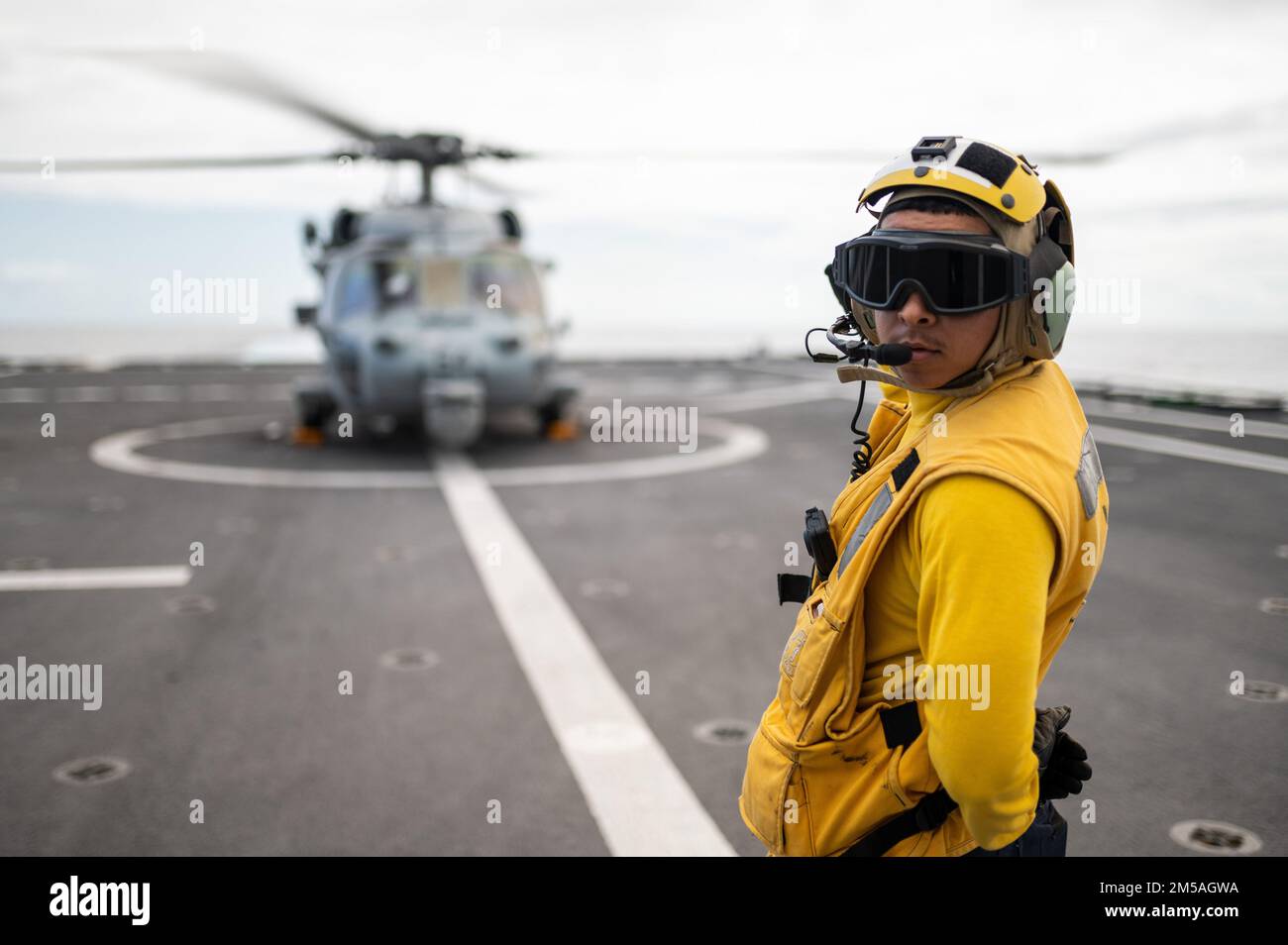 220216-N-LI768-1017 PHILIPPINE SEA (16. Februar 2022) – Boatswain’s Mate Seaman Damian Guerraguerra, aus Las Vegas, bereit, einen MH-60s Sea Hawk Helikopter zu starten, der den „Blackjacks“ der Helicopter Sea Combat Squadron (HSC) vom Flugdeck aus auf dem LUSS 16 Tulsa (Littoral Kampfschiff der Independence-Variante) zugewiesen ist. Tulsa, Teil der Destroyer Squadron (DESRON) 7, befindet sich in einem Rotationseinsatz und ist im US-amerikanischen 7.-Flottengebiet tätig, um die Interoperabilität mit Partnern zu verbessern und als einsatzbereite Einsatztruppe zur Unterstützung einer freien und offenen Region Indo-Pazifik zu dienen. Stockfoto
