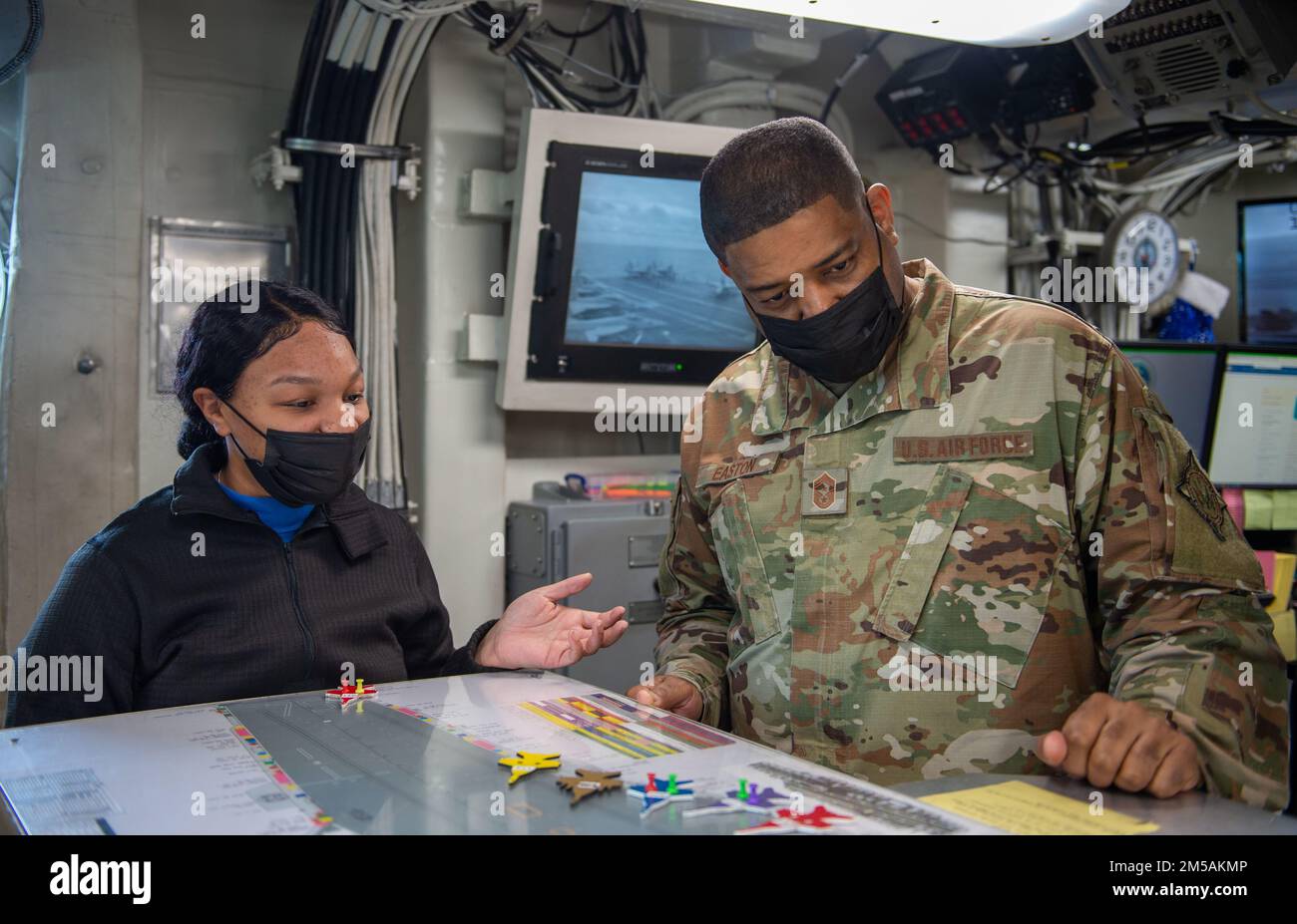 220216-N-ZE328-1444 MITTELMEER (16. Februar 2022) Aviation Boatswain's Mate (Handling) 3. Class Aymier Nevels, links, aus Lithonia, Georgia, Briefs Chief Master Sgt. Philip Easton, Chief Master Sergeant der USA Europäisches Kommando, in der Flugdeckkontrolle an Bord des Flugzeugträgers USS Harry S. Truman der Nimitz-Klasse (CVN 75), 16. Februar 2022. Die Harry S. Truman Carrier Strike Group befindet sich in einem geplanten Einsatz in den USA Sechstes Flottengebiet zur Unterstützung von Marineeinsätzen zur Aufrechterhaltung der maritimen Stabilität und Sicherheit und zur Verteidigung der Interessen der USA, Verbündeten und Partner in Europa und Afrika. Stockfoto