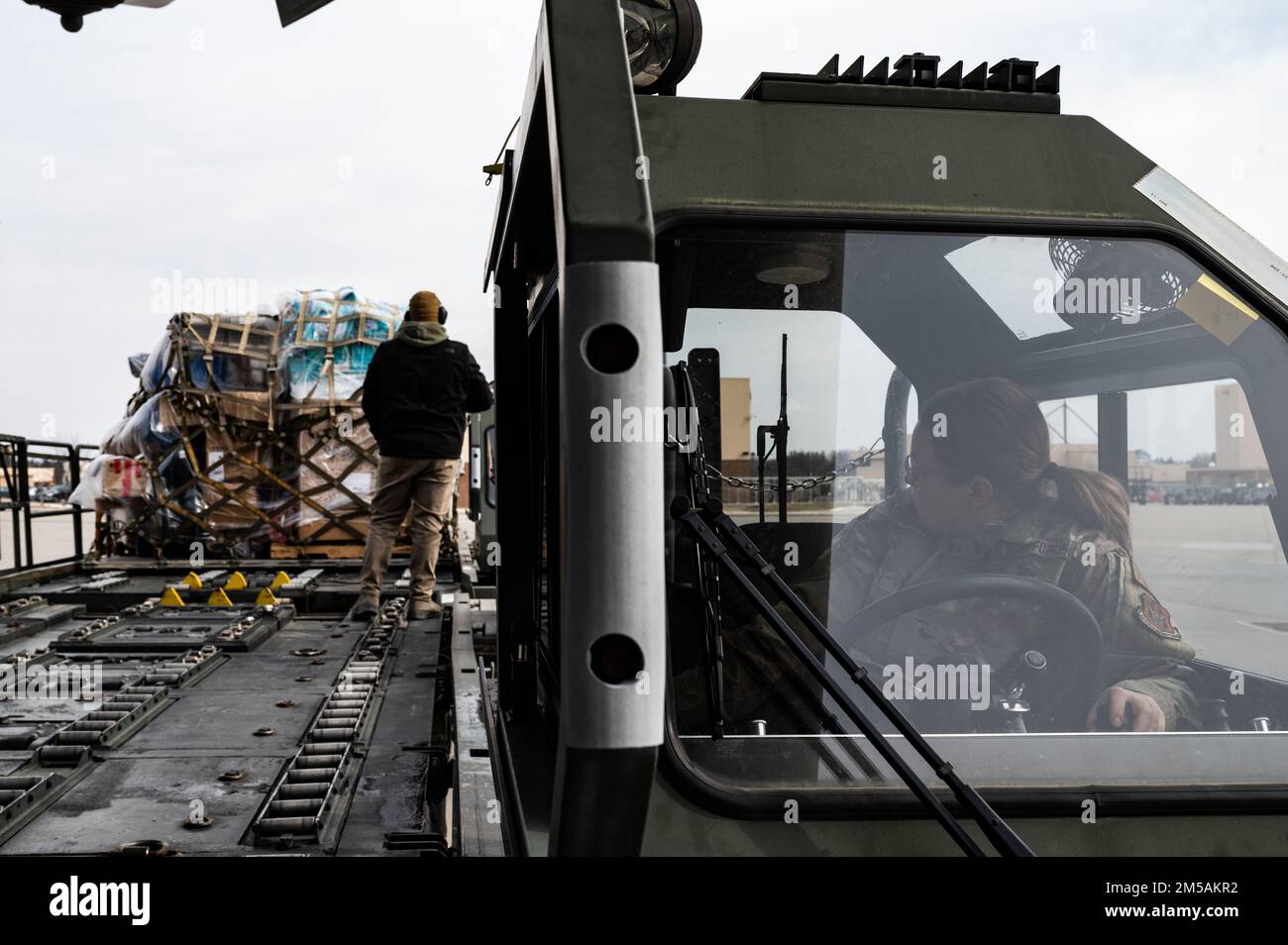 Tech. Sgt. Lauren Pollastro, 32. Aerial Port Squadron Passenger Operations Supervisor, beobachtet, wie Flugzeugkollegen Fracht von einem 25K Halverson Lader zu einem anderen an der Pittsburgh International Airport Air Reserve Station, Pennsylvania, 3. Januar 2022 transportieren. Der Halverson-Lader kann bis zu 25 kg Fracht aufnehmen und ermöglicht es den dem 32. APS zugewiesenen Flugzeugen, Fracht sicher und effektiv auf den C-17 Globemaster III zu transportieren und zu laden Stockfoto