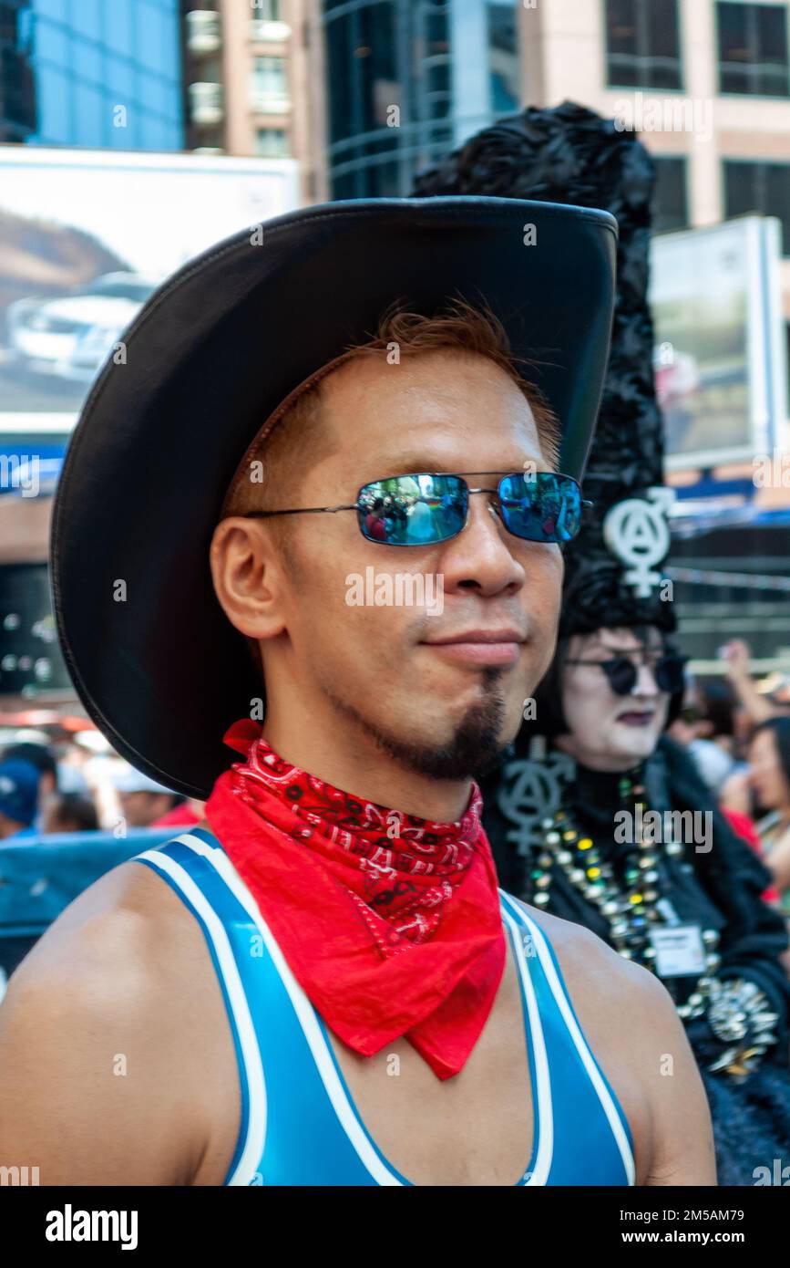 Ein junger Mann mit einem Cowboy-Look marschiert in die Innenstadt. Er ist Teil der jährlichen Feier der LGBTQ+ Community Stockfoto