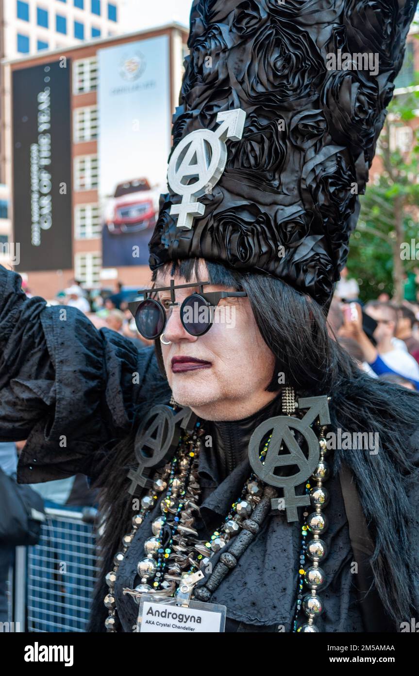 Porträt einer Person in schwarzer Kleidung. Da ist ein Schild mit der Aufschrift Androgyna alias Cristal Kronleuchter Stockfoto