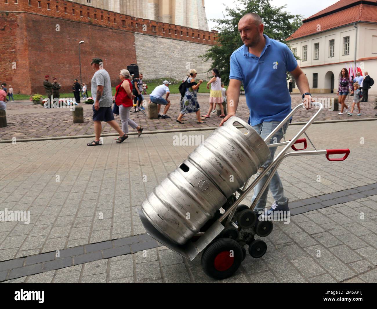 Krakau. Krakau. Polen. Ein Mann trägt zwei Fässer Bier die Straße runter auf einem Handwagen. Stockfoto