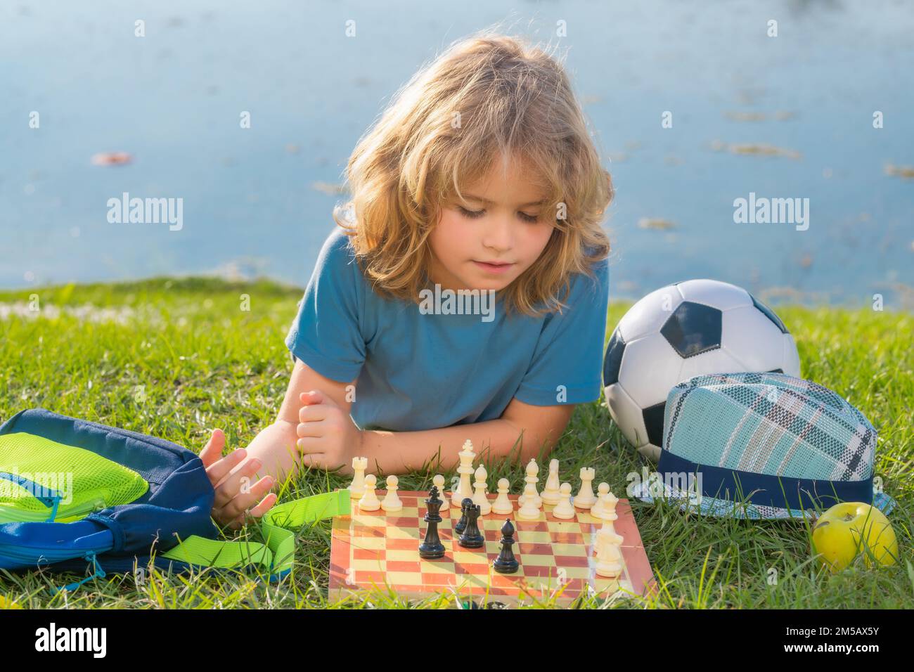 Kluger Junge, der Schach spielt. Kluges Kind, das an Schach denkt. Stockfoto