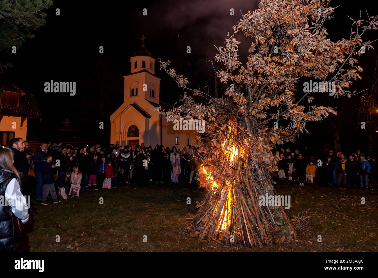 BANJANI, SERBIEN - 6. JANUAR 2022: Das serbische Volk sieht vor dem orthodoxen Heiligabend eine zeremonielle Verbrennung von Yule-Baumstämmen oder Badnjak-Zweigen Stockfoto