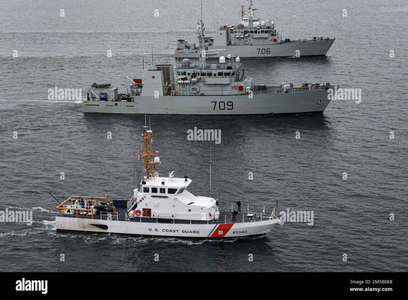 Küstenwache Blauhai [WPB 87360] durchquert die Gewässer der Salish-See entlang HMCS Saskatoon und HMCS Yellowknife während einer gemeinsamen Übung am 17. Februar 2022. Die Übung wurde durchgeführt, um Royal Canadian Navy Crews für Einsätze zur Unterstützung der US-Drogenbekämpfung zu Schulen und vorzubereiten. Stockfoto