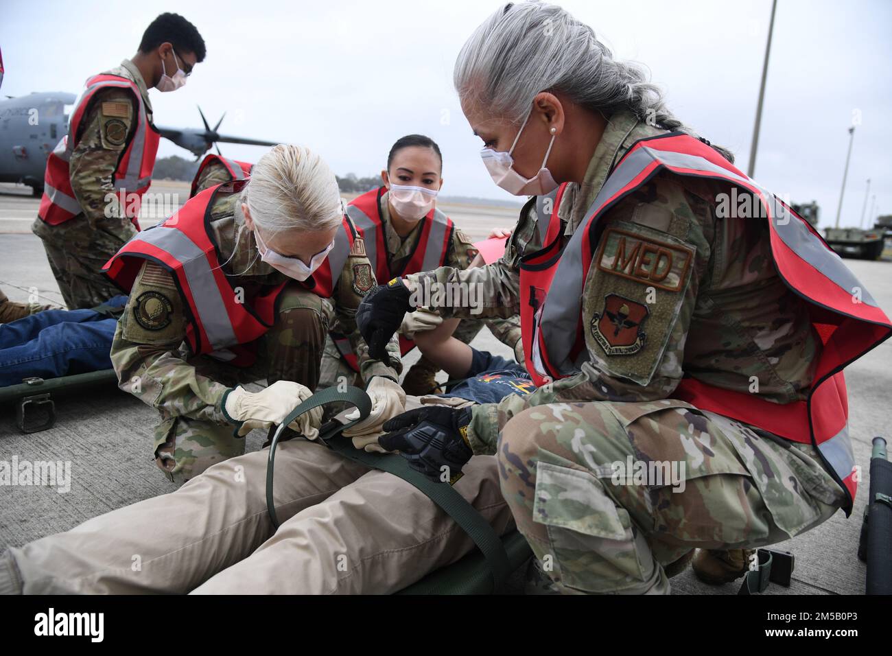 Mitglieder der 81. Medical Group sichern Patienten auf Tragen während der National Disaster Medical System Übung vor dem 41. Aerial Port Squadron Gebäude am Keesler Air Force Base, Mississippi, 17. Februar 2022. Das Federal Coordination Center von Keesler wurde aktiviert und erhielt während des Übungsszenarios mehr als 20 Patienten. Dazu gehörte auch der Ausbruch des Versagens von New Madrid, der ein Erdbeben in Tennessee auslöste, das erhebliche Schäden verursachte und viele Menschen verletzte. Die Mitglieder der MDG 81. nahmen an der Veranstaltung Teil, um sich besser auf die realen Situationen vorzubereiten. Stockfoto