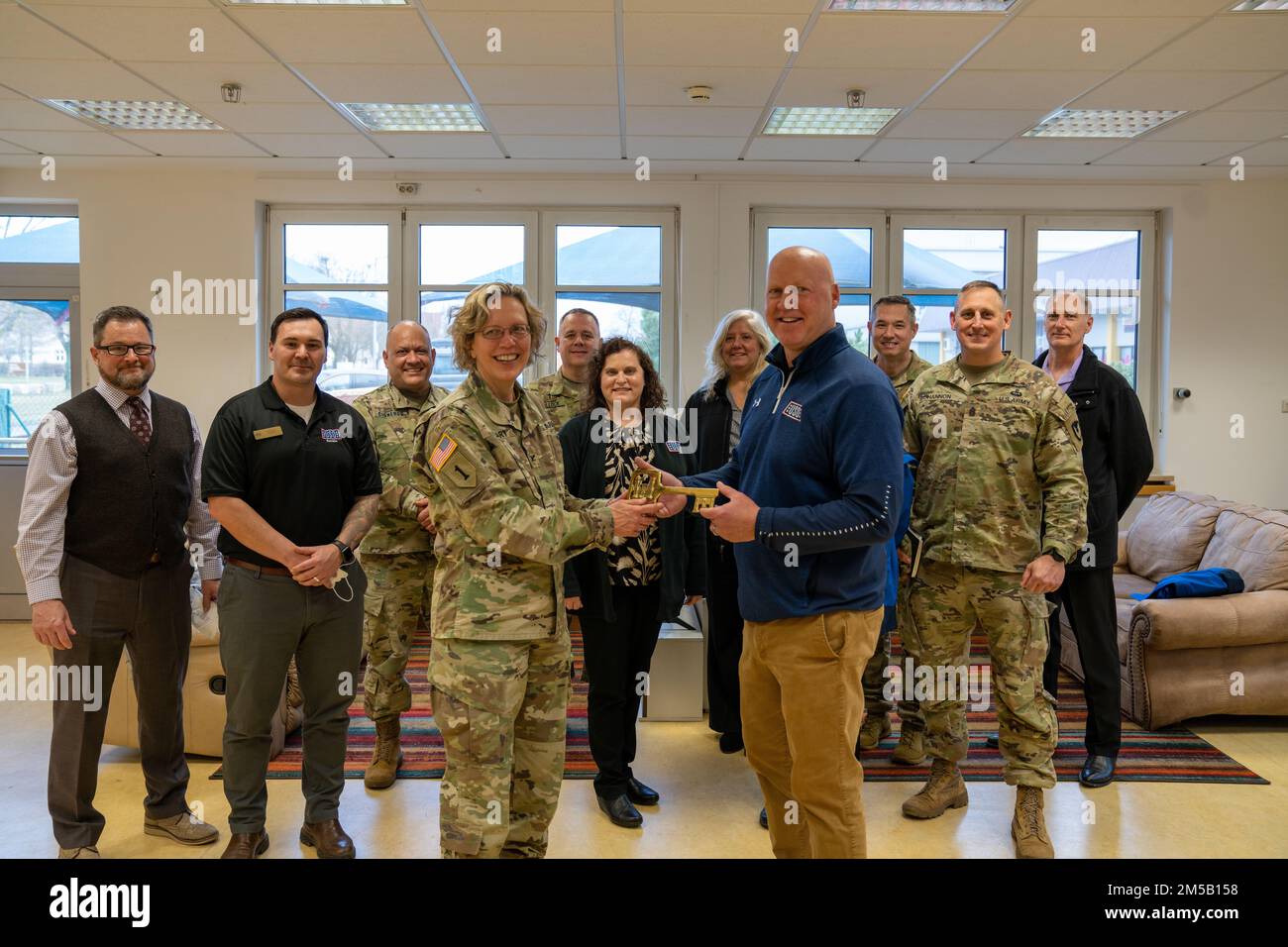 Oberst Karen Hobart (vorne links) übergibt Grant McCormick, Regional Vice President von USO Europa, Naher Osten und Afrika (vorne rechts), den Schlüssel zum neuen Ansbach USO Center in Katterbach Kaserne. United States Organizations Inc (USO) Führungsverhalten Treffen mit der USAG Ansbach Kommandogruppe und den Direktoren während einer Tour durch das zukünftige Ansbach USO Center am Katterbach Kaserne am 17. Februar 2022. Stockfoto