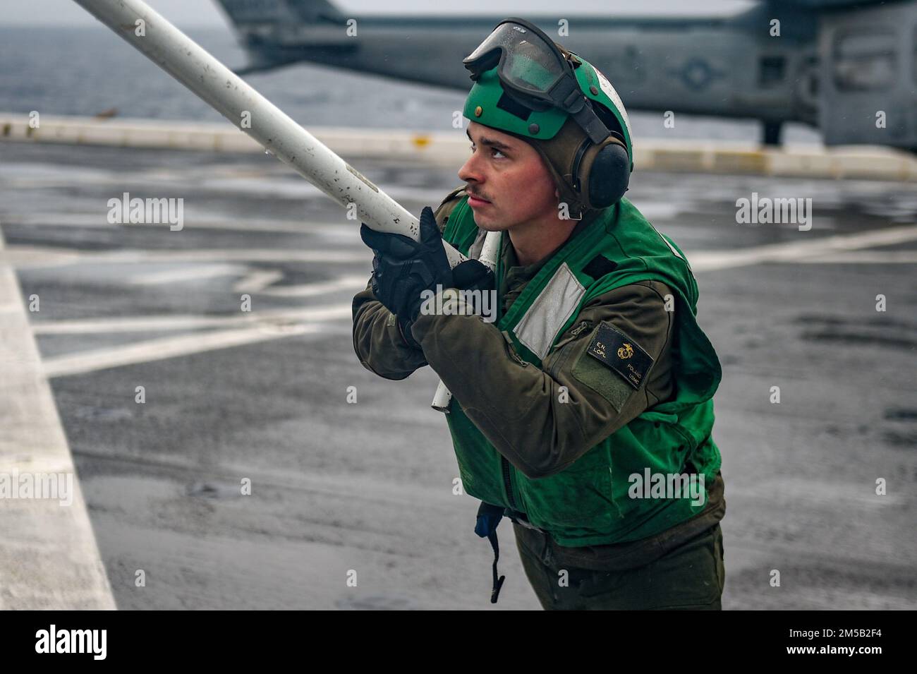 PHILIPPINE SEA (17. Februar 2022) Lance CPL. Elijah Polen aus Clarkrange, Tennessee, dem 31. Marine Expeditionary Unit (MEU) zugeteilt, schließt Rotorblätter auf einem AH-1Z Cobra Hubschrauber vom Marine Medium Tilt Rotor Squadron (VMM) 265 auf dem Cockpit des Amphibienschiffs USS Green Bay (LPD 20). Green Bay, Teil der Expeditionary Strike Group 7, ist zusammen mit der 31. MEU im Zuständigkeitsbereich der US-amerikanischen 7.-Flotte tätig, um die Interoperabilität mit Verbündeten und Partnern zu verbessern und als einsatzbereite Eingreiftruppe zur Verteidigung von Frieden und Stabilität in der Region Indopazifik zu dienen. Stockfoto