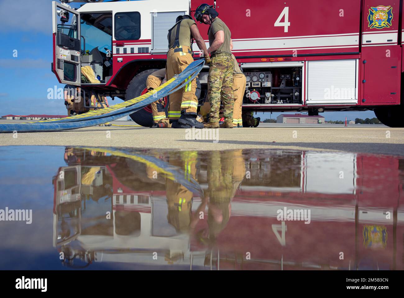 USA Flugzeuge der 6. Bauingenieurschwadron bedienen einen Feuerwehrschlauch während einer Major Accident Response Exercise (MARE) auf dem Luftwaffenstützpunkt MacDill, Florida, 17. Februar 2022, der 6. CES Fire and Emergency Services Flug geschult, um Reaktionszeiten während eines simulierten Notfallszenarios sicherzustellen. Stockfoto