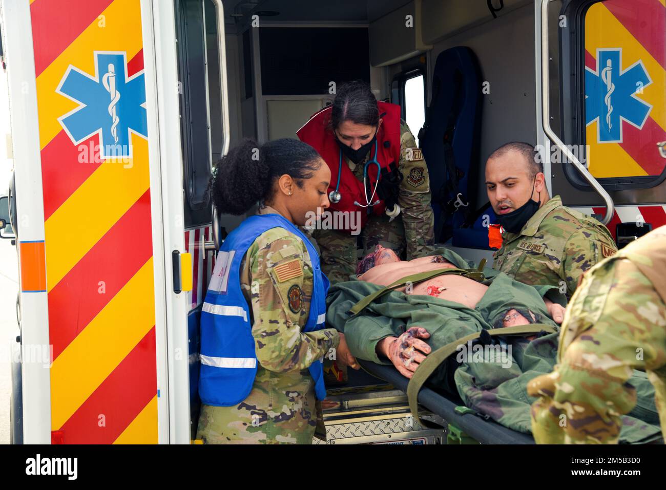 USA Airmen der 6. Medical Group (MDG) heben eine Prüfpuppe in einen Krankenwagen während einer Major Accident Response Exercise (MARE) am MacDill Air Force Base, Florida, 17. Februar 2022. Flugzeuge, die der 6. MDG zugewiesen werden, trainieren ständig, um eine effektivere medizinische Unterstützung zu leisten, und bleiben bereit, wenn ein Notfall in der realen Welt eintreten sollte. Stockfoto