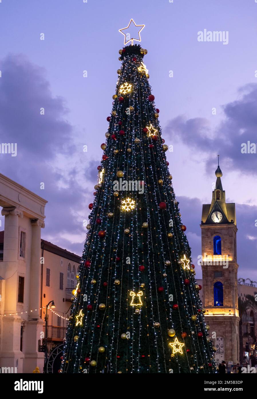 Ein großer dekorierter Weihnachtsbaum neben dem Jaffa-Uhrenturm in Israel Stockfoto