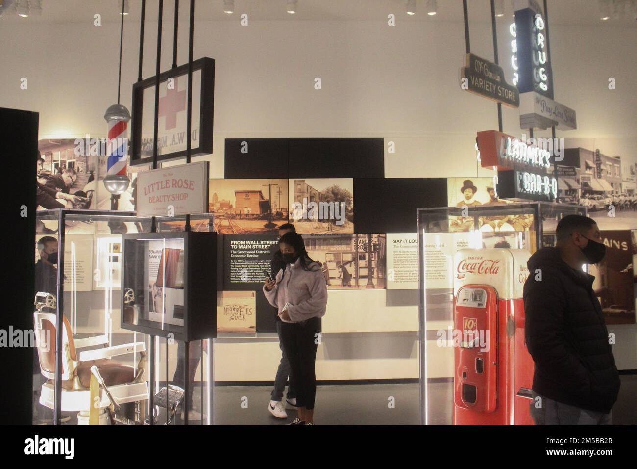 Flugzeuge des 97. Air Mobility Wing und ihre Familien lesen über die Jahre nach dem Massaker von Tulsa im Greenwood Rising Black Wall Street History Center in Tulsa, Oklahoma, am 18. Februar 2022. Innerhalb von 10 Jahren nach dem Massaker bauten die Schwarzen Tulsaner einen Großteil des Greenwood District wieder auf, und bis 1941 gab es über 240 Unternehmen in schwarzem Besitz. Stockfoto