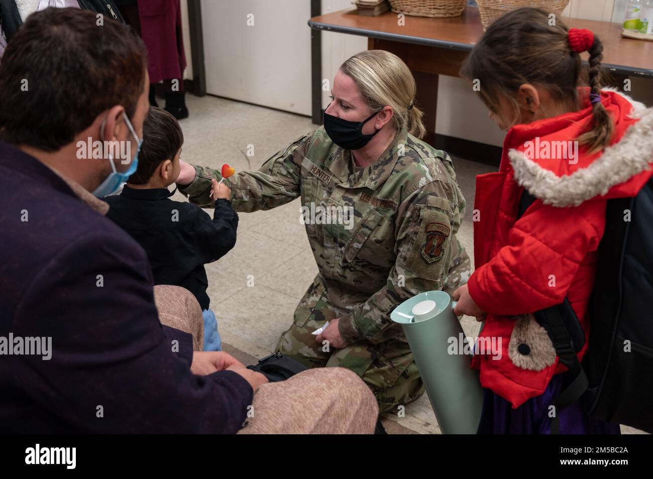 Ein Mitglied der Task Force Liberty interagiert mit einer afghanischen Familie vor ihrer Abreise auf der Joint Base McGuire-Dix-Lakehurst, New Jersey, 19. Februar 2022. Die Gäste waren die letzten Abreisen, um ihre Neuansiedlung von der Task Force Liberty abzuschließen. Das Verteidigungsministerium, durch die USA Das Northern Command und zur Unterstützung des Department of Homeland Security bietet so schnell wie möglich Transport, temporäre Unterbringung, medizinische Untersuchungen und allgemeine Unterstützung für mindestens 11.000 afghanische Evakuierte in Liberty Village in permanenten oder temporären Strukturen. Diese Initiative stellt afghanisches Personal zur Verfügung Stockfoto
