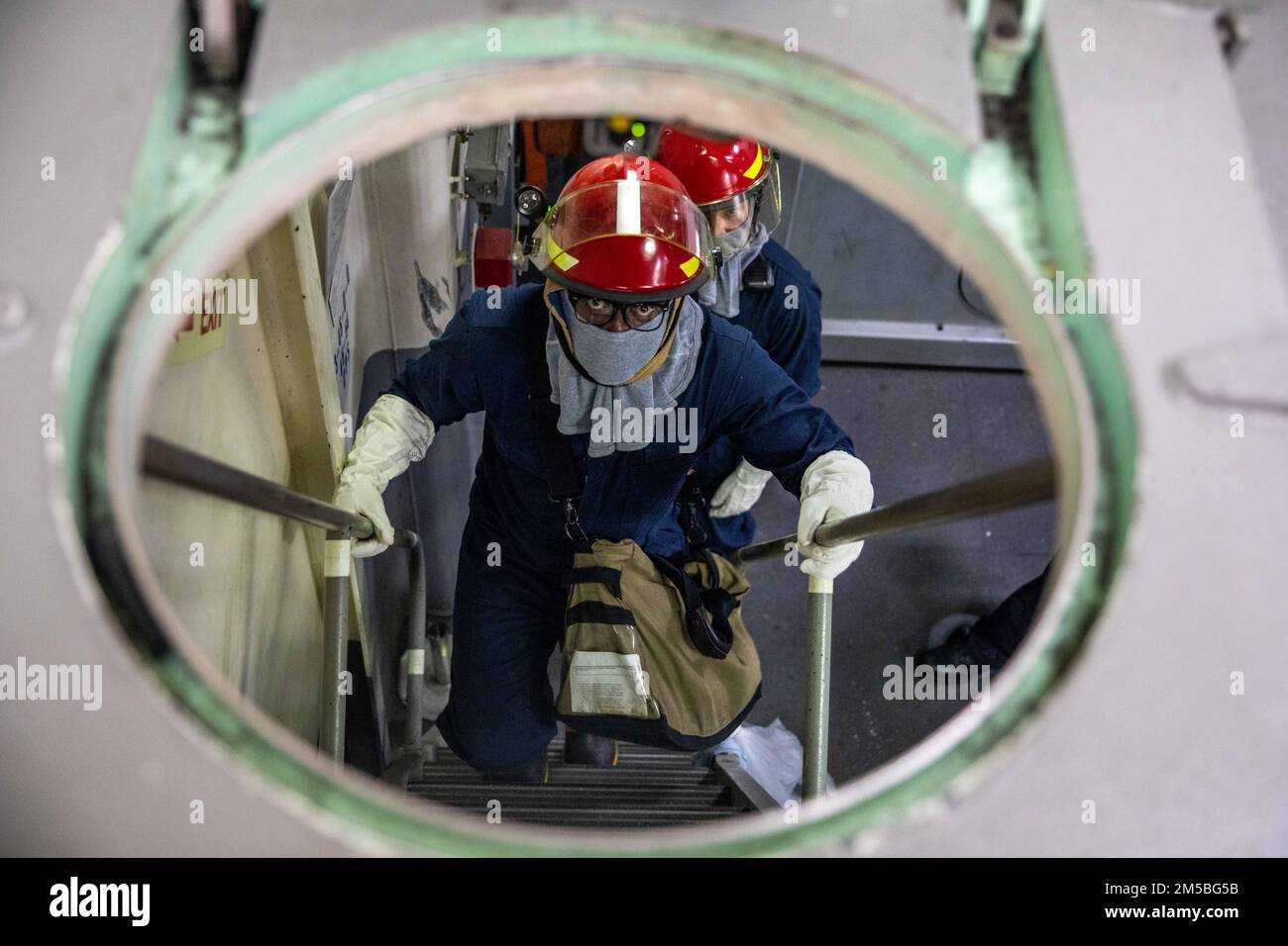 220222-N-HD110-1025 KARIBISCHES MEER - (22. Februar 2022) -- Feuerwehrmann 1. Klasse Rohan Brown klettert während einer Übung des Schadenskontrollteams an Bord des Kampfschiffs USS Milwaukee (LCS 5) der Freiheitsvariante USS Milwaukee (LCS), 22. Februar 2022. Milwaukee wird in das US-Flottengebiet 4. entsandt, um die Mission der Joint Interagency Task Force South zu unterstützen, zu der auch Missionen zur Bekämpfung des illegalen Drogenhandels in der Karibik und im östlichen Pazifik gehören. Stockfoto