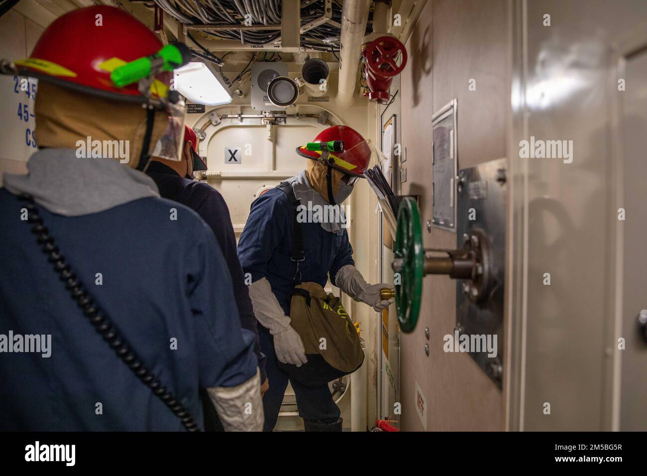 220222-N-HD110-1021 CARIBBEAN SEA - (22. Februar 2022) -- Fire Controlman 1. Class Rohan Brown simuliert die Überprüfung auf Matrosen in Liegeplätzen während einer Übung des Schadenskontrollteams an Bord des Kampfschiffs USS Milwaukee (LCS 5) der Freiheitsvariante, 22. Februar 2022. Milwaukee wird in das US-Flottengebiet 4. entsandt, um die Mission der Joint Interagency Task Force South zu unterstützen, zu der auch Missionen zur Bekämpfung des illegalen Drogenhandels in der Karibik und im östlichen Pazifik gehören. Stockfoto