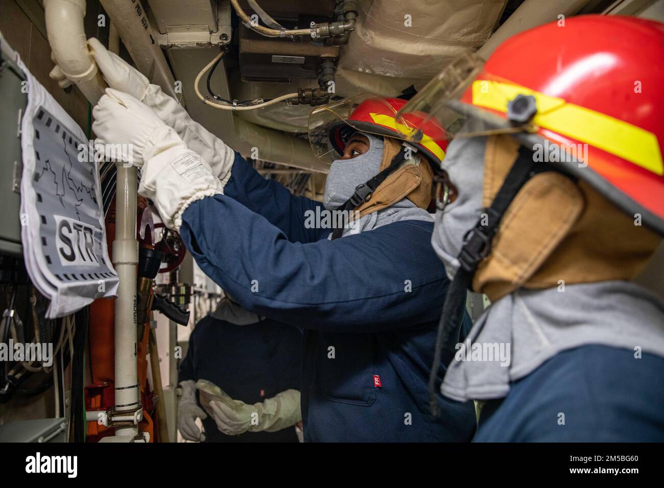 220222-N-HD110-1034 KARIBISCHES MEER - (22. Februar 2022) -- Feuerwehrmann 1. Klasse Malcolm Hendersoncoles simuliert das Aufbringen eines Notwasserpflasters (EWARP) auf einem Rohr während einer Übung des Schadenskontrollteams an Bord des Kampfschiffs Freedom-Variant littoral USS Milwaukee (LCS 5), 22. Februar 2022. Milwaukee wird in das US-Flottengebiet 4. entsandt, um die Mission der Joint Interagency Task Force South zu unterstützen, zu der auch Missionen zur Bekämpfung des illegalen Drogenhandels in der Karibik und im östlichen Pazifik gehören. Stockfoto