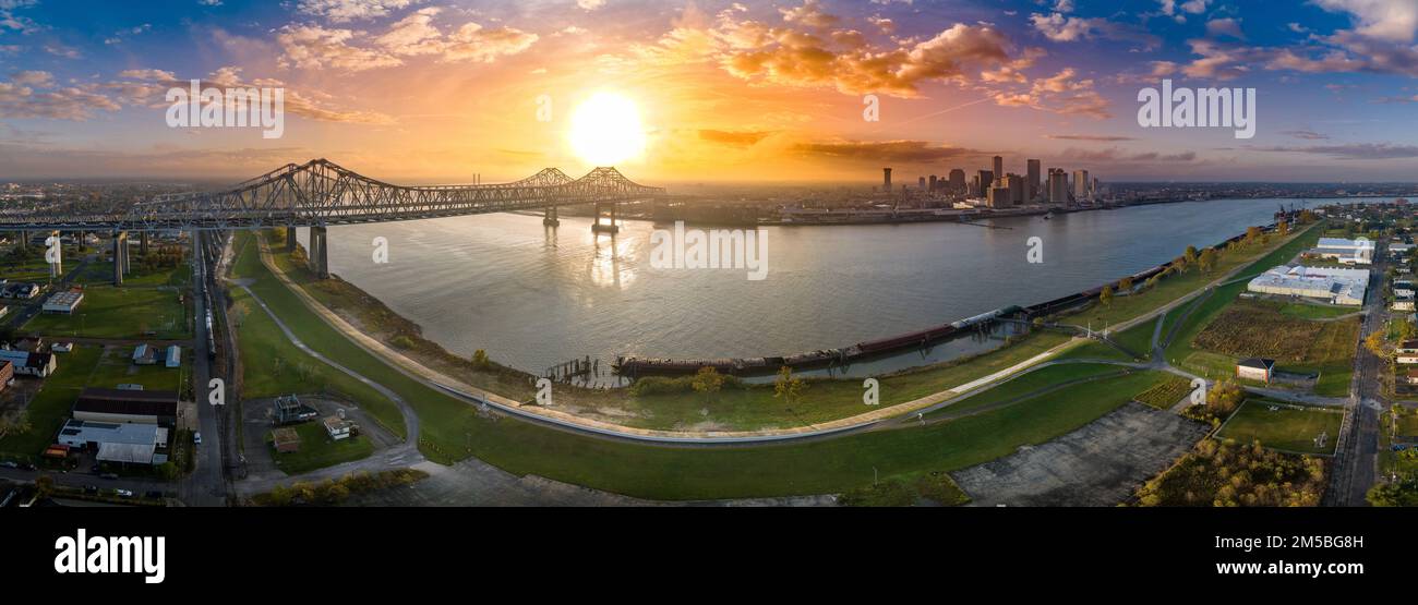 Panoramablick auf die Innenstadt von New Orleans, den Mississippi und die Crescent City Connection Bridge mit farbenfrohem Sonnenuntergang Stockfoto