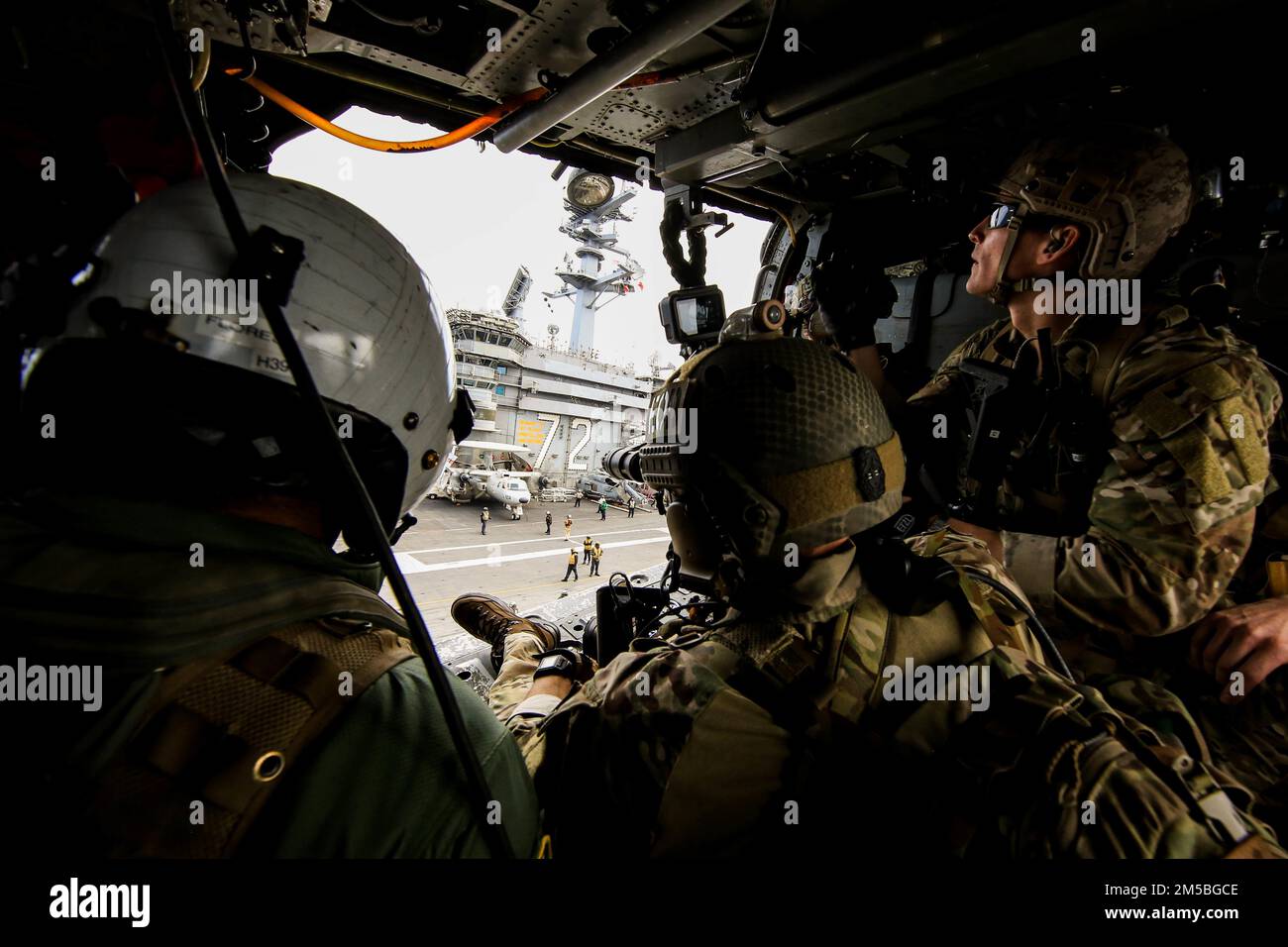 PHILIPPINISCHE SEELEUTE (22. Februar 2022), die der mobilen Einheit für die Entsorgung von Sprengstoffen (EODMU) 3 zugeteilt sind, fliegen in einem MH-60s Sea Hawk Hubschrauber, der den ‚Chargers‘ der Helicopter Sea Combat Squadron (HSC) 14 zugeteilt ist, nach dem Abflug vom Cockpit des Flugzeugträgers USS Abraham Lincoln der Nimitz-Klasse (CVN 72) in Vorbereitung auf die Ausbildung im Hubschrauber, Besuch, Einstieg, Durchsuchung und Beschlagnahme (HVBSS). Die Abraham Lincoln Strike Group wird planmäßig im 7.-Flottenbereich der USA eingesetzt, um die Interoperabilität durch Allianzen und Partnerschaften zu verbessern und gleichzeitig als Stockfoto