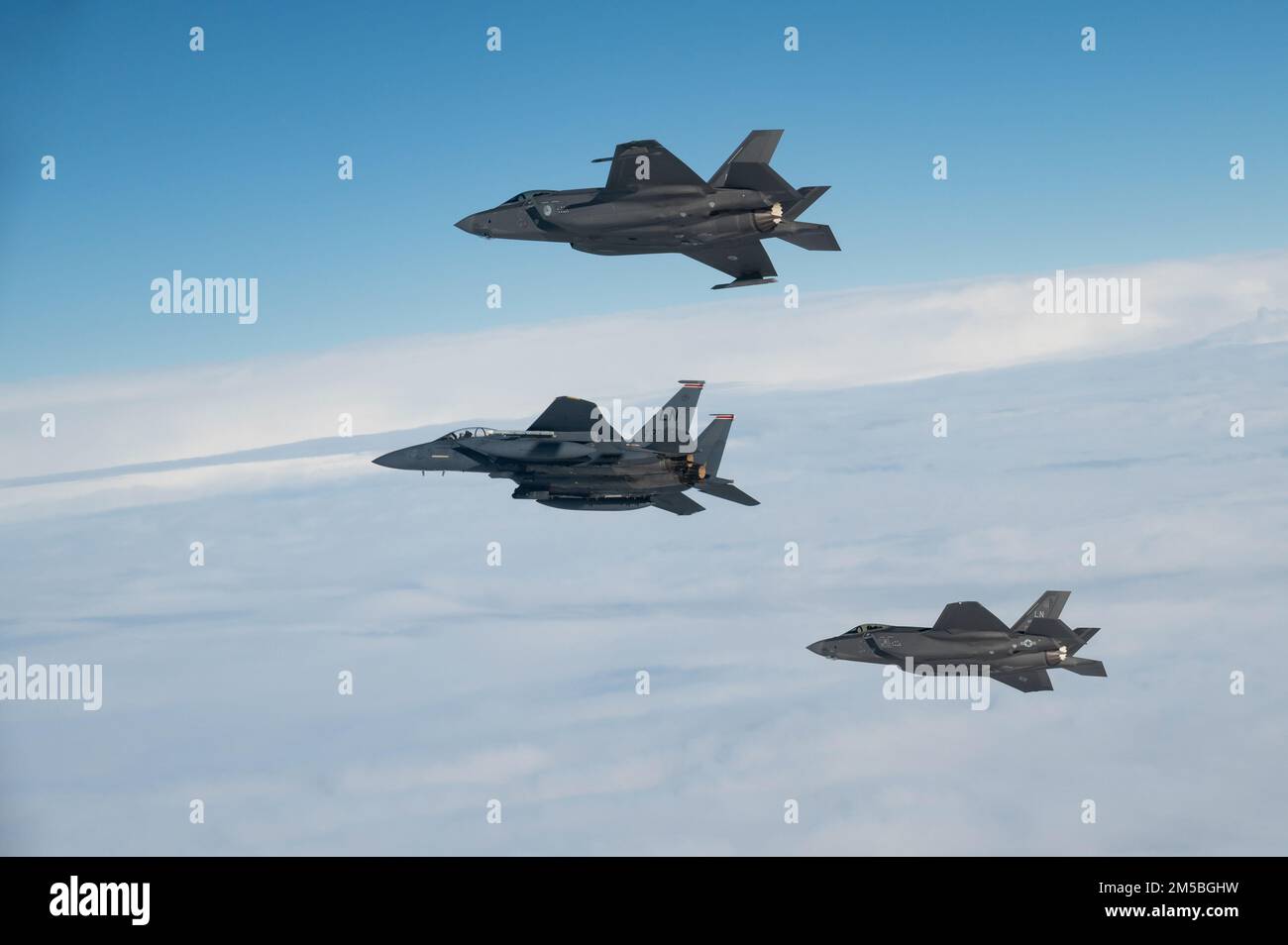 EIN US-AMERIKANISCHER Air Force F-15E Strike Eagle leitet eine drei-Schiff-Formation mit US- und niederländischen F-35A Lightning II-Flugzeugen während einer bilateralen Air-to-Air-Übung über den Niederlanden am 22. Februar 2022. Die Ausbildung sollte die Interoperabilität verbessern und es den Vereinten Kräften ermöglichen, kohärent und wirksam zusammenzuarbeiten, um militärische Ziele zu erreichen. Stockfoto