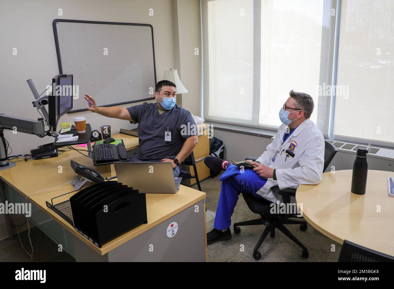 LAWRENCE, Mass. – USA Air Force Tech. Sgt. Tomas Gonzales, Left, ein Verwaltungstechniker, der dem medizinischen Team des Militärs zugeteilt wurde, in Lawrence, Massachusetts, und den USA Major Justin O'Keefe, ein Arzt, der auch in den USA tätig ist Militärmedizinisches Team der Luftwaffe trifft sich zur Erörterung von Krankenhausplänen im Rahmen der COVID-Response-Operationen, Feb. 22, 2022, USA Nördliches Kommando, durch die USA Army North ist nach wie vor entschlossen, das Verteidigungsministerium flexibel bei der COVID-Reaktion der gesamten Regierung zu unterstützen. Stockfoto