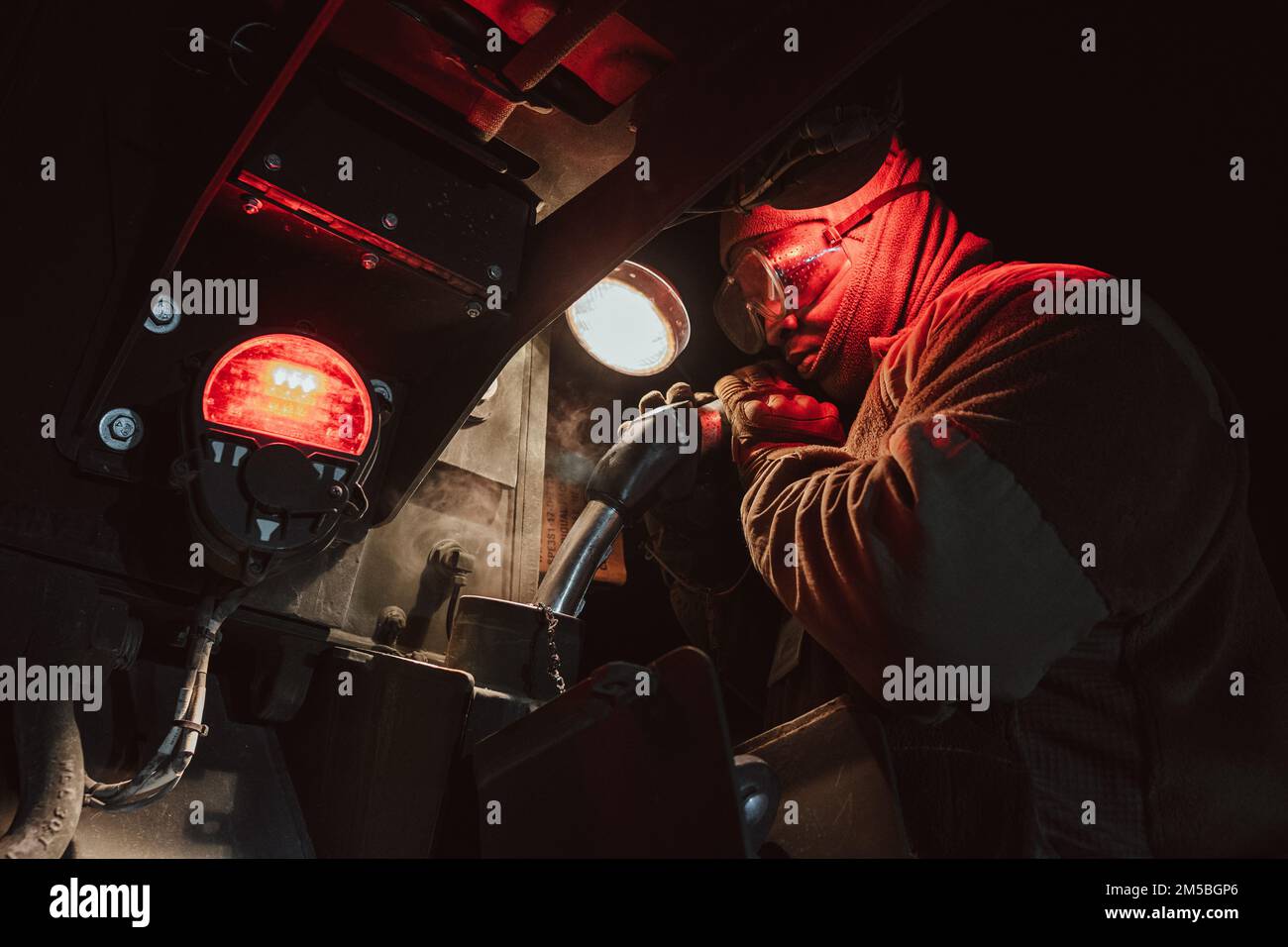 EIN US-AMERIKANISCHER Soldat der Armee unterstützt das 3. Geschwader, 2D. Kavallerie-Regiment, indem er seine Fahrzeuge auf einer taktischen Straße am 22. Februar 2022 betankt. 2CR unternimmt einen taktischen wintermarsch über 1500 km von Deutschland nach Lettland, um seine Fähigkeit zu demonstrieren, sich in einem strengen Umfeld einzusetzen, multinationale Beziehungen zu fördern und die Interoperabilität mit seinen NATO-Verbündeten und -Partnern zu verbessern. Stockfoto