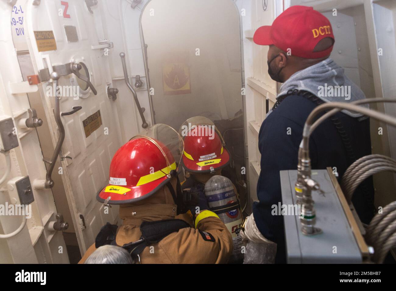 220222-N-VQ947-1009 PAZIFIK (22. Februar 2022) – Matrosen fangen während einer Übung zur Schadensbegrenzung an Bord der Amphibien-Transportanlage USS Portland (LPD 27) der San Antonio-Klasse am 22. Februar 2022 an, einen simulierten Brand der Klasse Alpha auszulösen. Matrosen und Marines der Essex Amphibious Ready Group (ARG) und der 11. Marine Expeditionary Unit (MEU) führen derzeit Routineeinsätze in der US-3.-Flotte durch. Stockfoto