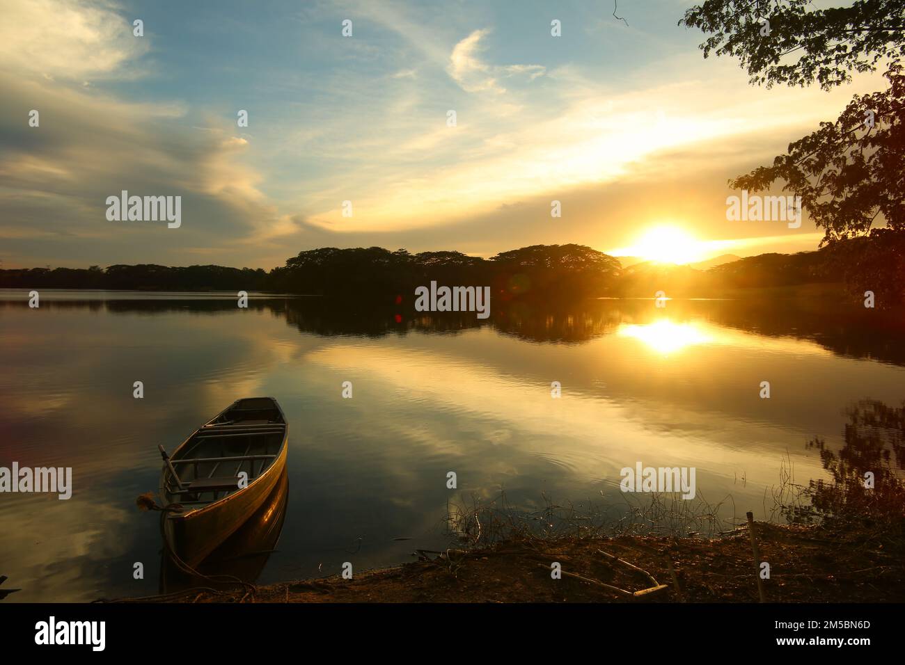 Boot auf dem See mit Sonnenuntergang und blauem Himmel Stockfoto