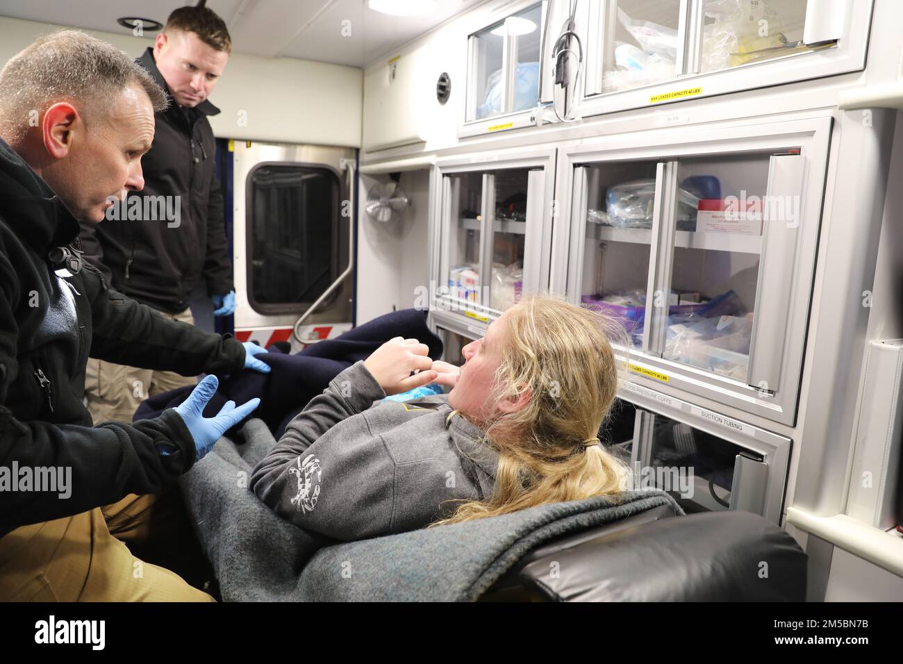 Major Jason Myer, Assistentin des Arztes, Left, und Sergeant 1. Klasse Eric Kelly, Spezialist für Gesundheitsfürsorge, konsultieren ihren Patienten, Sergeant 1. Klasse Kim Kerschner, Anne Arundel County Freiwillige Feuerwehrmann, alle Mitglieder des Maryland National Guard 32. Waffen der Massenvernichtung Zivilunterstützungsteams, Während des Unfallszenarios einer pharmazeutischen Feldübung im Fünften Regiment-Armeekorps in Baltimore am 23. Februar 2022. Der 32. CST nutzt diese Art von Übung, um zu trainieren, damit sie immer bereit sind, die Zivilbehörden in einem heimischen chemischen, biologischen, Radiolog zu unterstützen Stockfoto